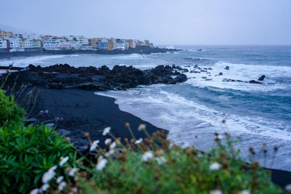 Explore the stunning black sand beach with rocky coastlines in Puerto de la Cruz, Tenerife, Spain.