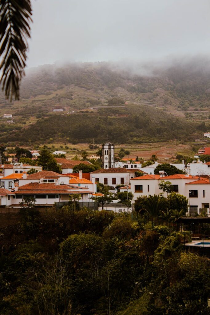 Captivating image of Tegueste village with mist-covered mountains in the background, highlighting rural architecture.