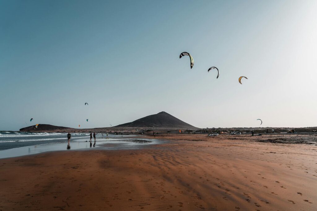 Kite surfers enjoy a thrilling beach day with perfect waves and clear skies.