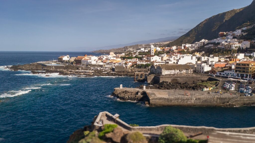 Aerial view of Garachico town along the rugged coastline of Tenerife, Spain, showcasing its charming architecture.