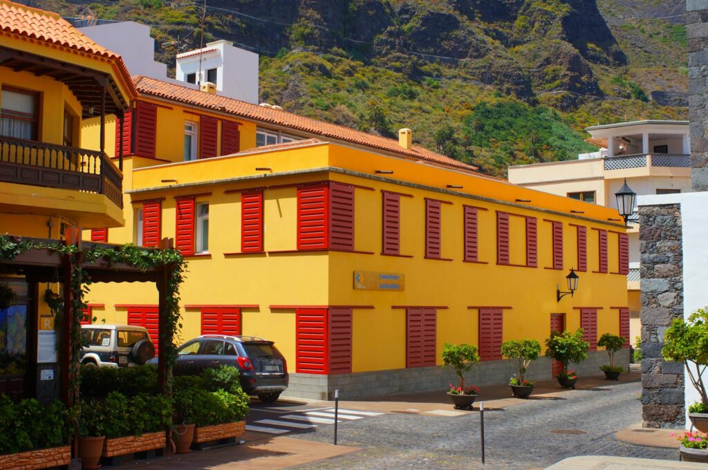 Charming yellow streetscape with red shutters in Garachico, Tenerife on a sunny day.