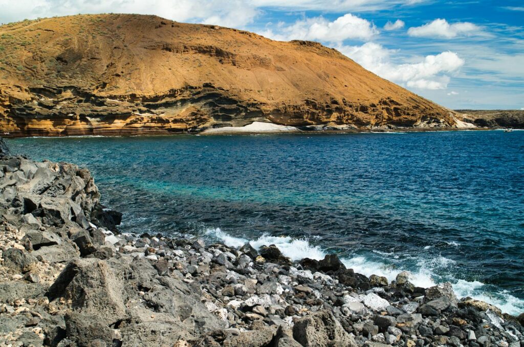 Explore the beautiful rocky coastline and clear blue waters of Tenerife, Spain's stunning landscape.