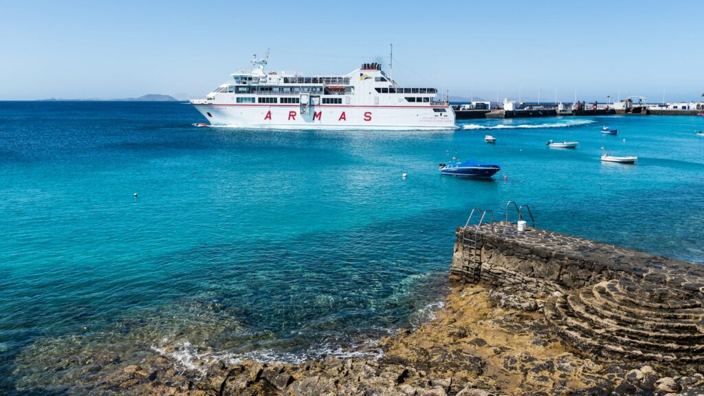 Peaceful ferry scene at Lanzarote's marina with azure waters and dockside view.