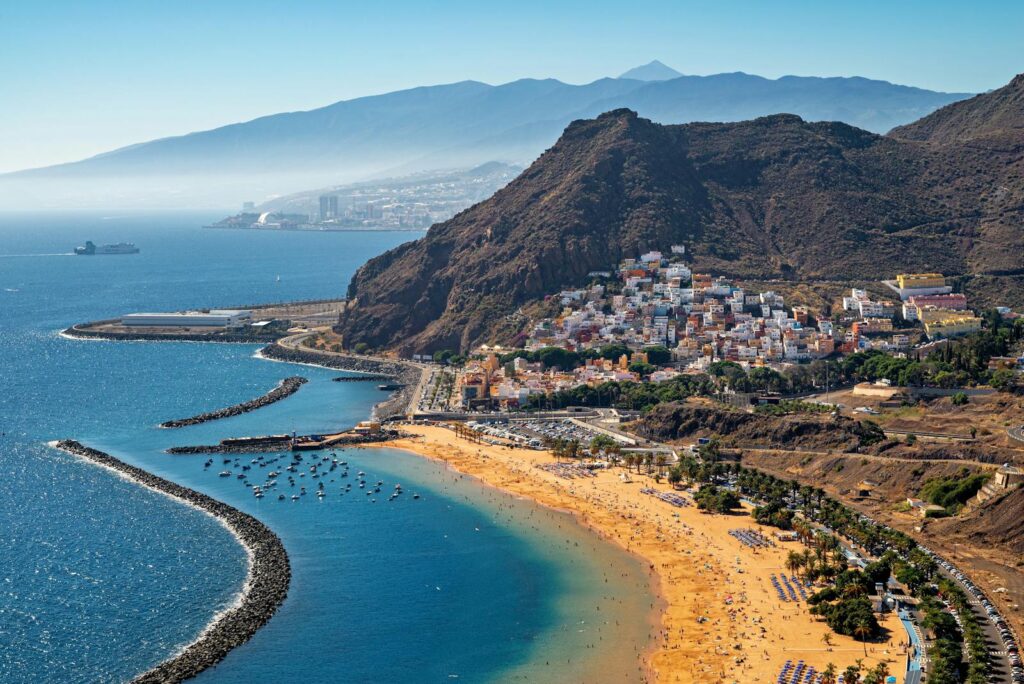 Stunning aerial view of Playa de Las Teresitas in Tenerife with mountainous backdrop.