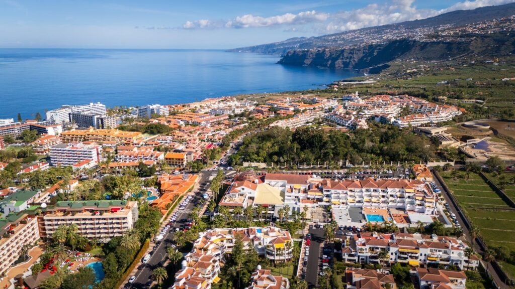 Scenic aerial view of Puerto de la Cruz, Tenerife, showcasing coastal landscape and city architecture.