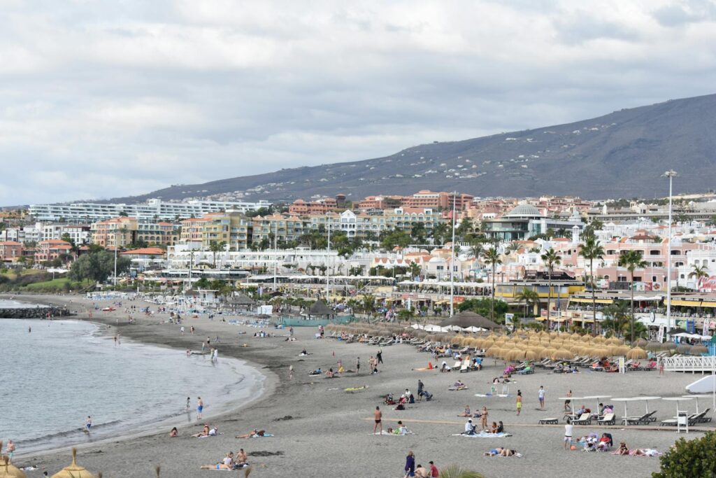 Relaxing beach scene at Playa de Fañabé in Costa Adeje, Tenerife, showcasing vibrant coastal life.