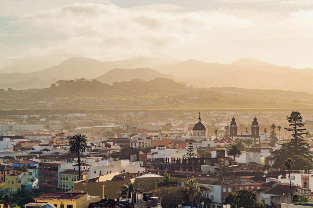 A breathtaking view of La Laguna with mountains and cityscape illuminated by golden hour light.