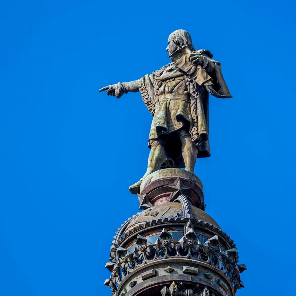 Low angle view of the Columbus Monument in Barcelona set against a bright blue sky.