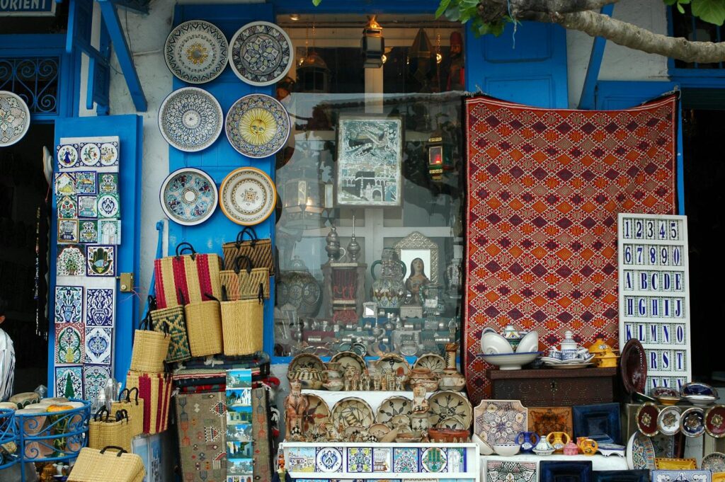 Vibrant display of traditional Moroccan crafts, ceramics, and textiles in a local artisan shop.