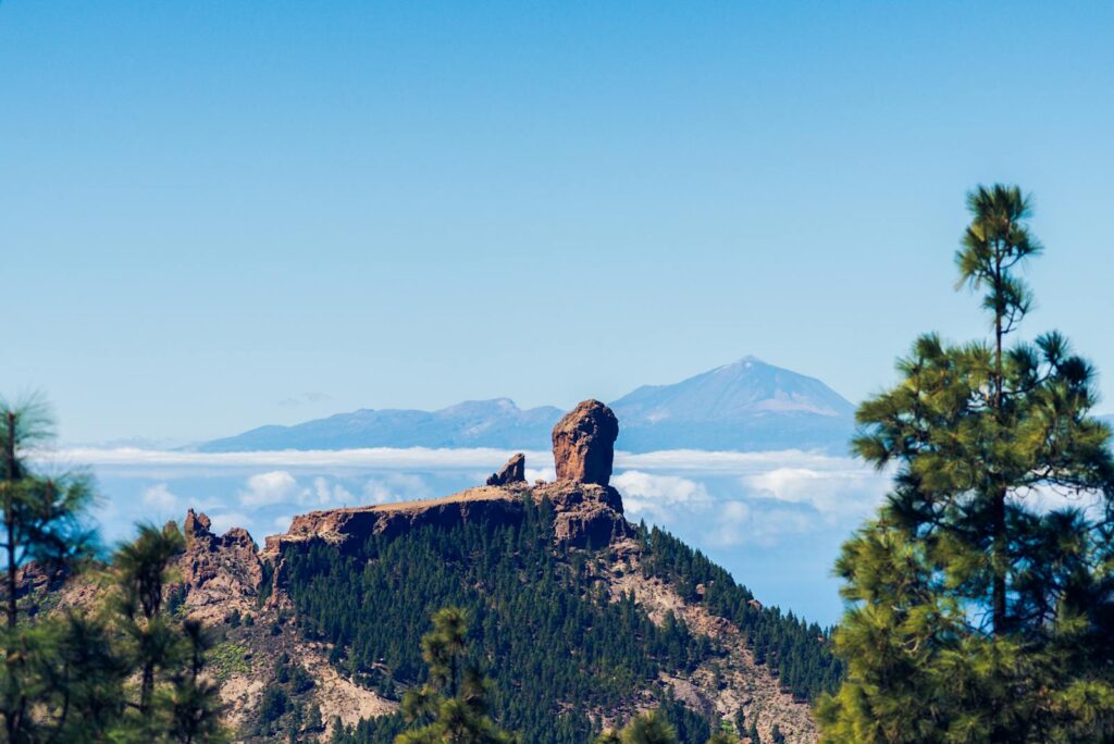 Stunning view of Roque Nublo surrounded by lush forests under a clear blue sky in Gran Canaria.