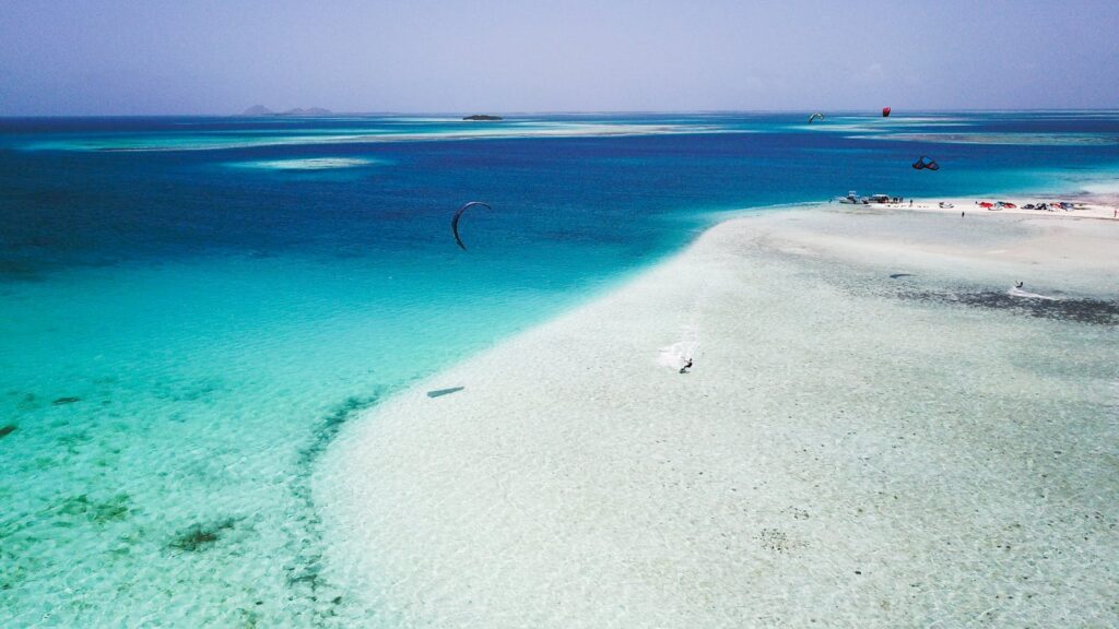 Stunning aerial shot capturing kitesurfing over turquoise waters in the Federal Dependencies of Venezuela.
