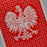 a close up of a red and white paper with a bird on it
