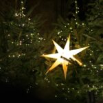 A lighted christmas tree with a star hanging from it